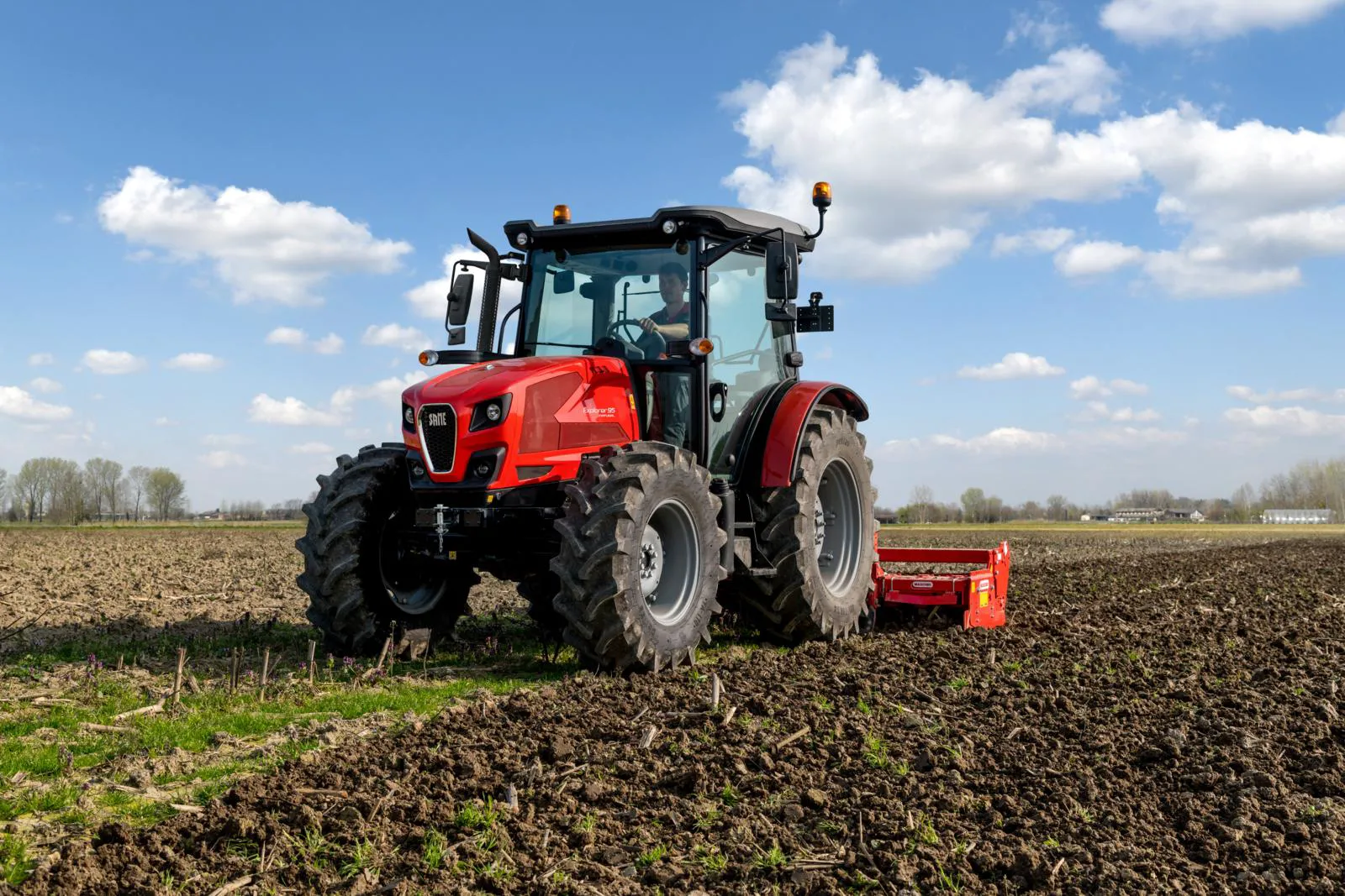 Red SAME tractor working an open field